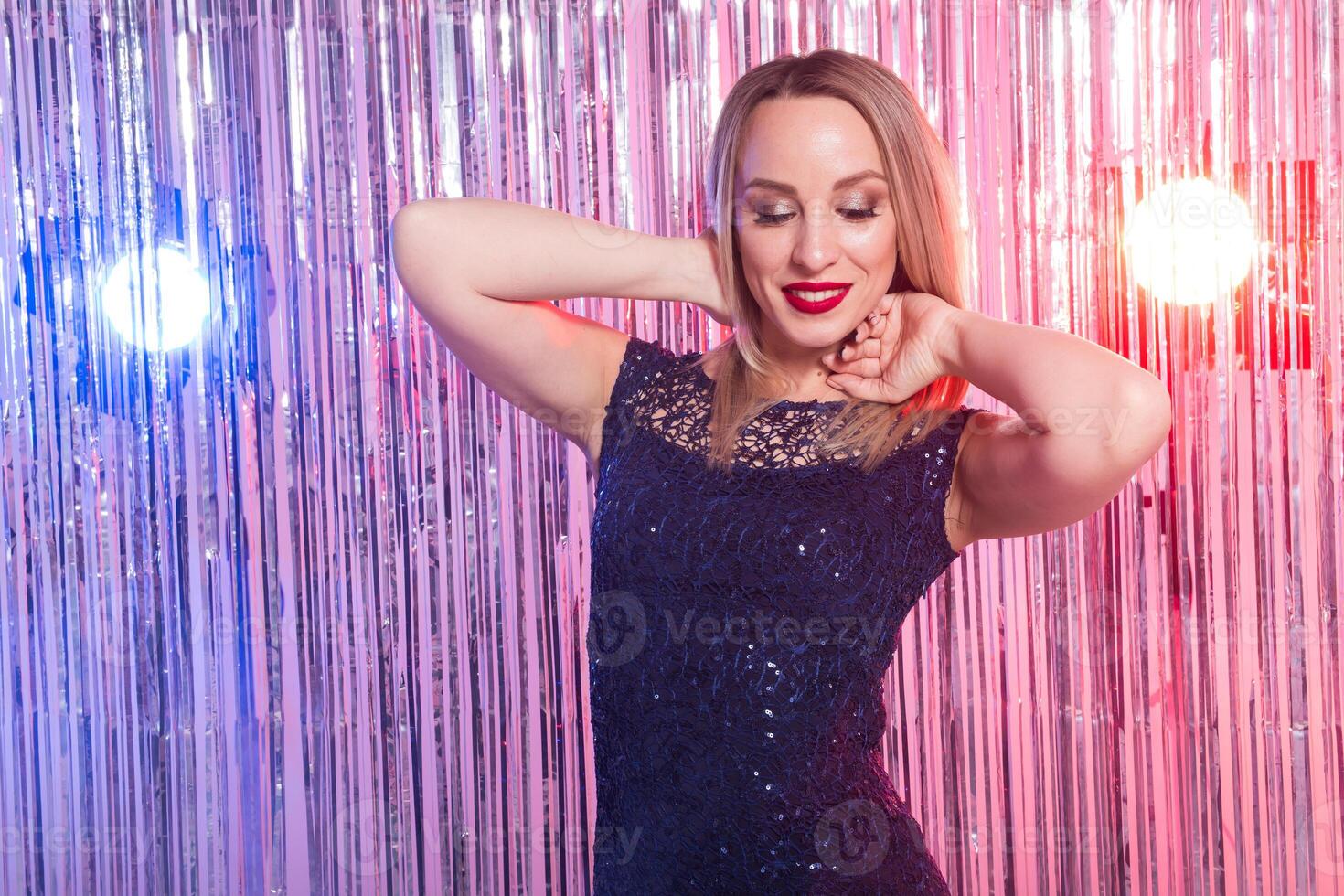 Blonde woman dancing at night disco club. Party, holidays and celebration photo