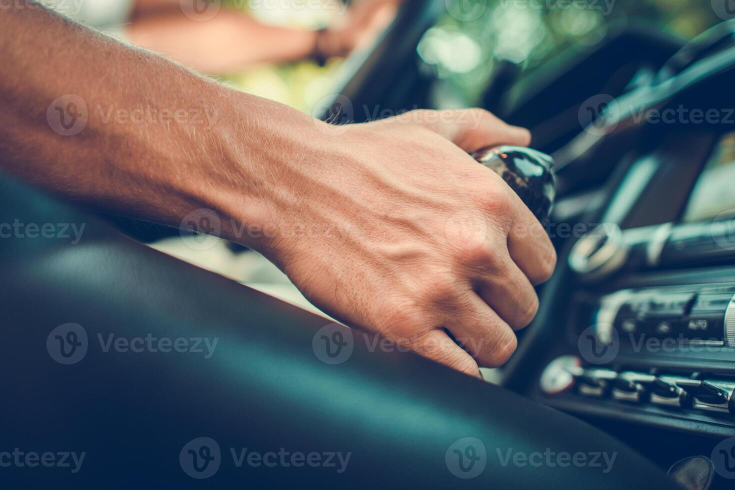 Driver Shifts Gears While Inside a Classic Car During a Sunny Afternoon photo