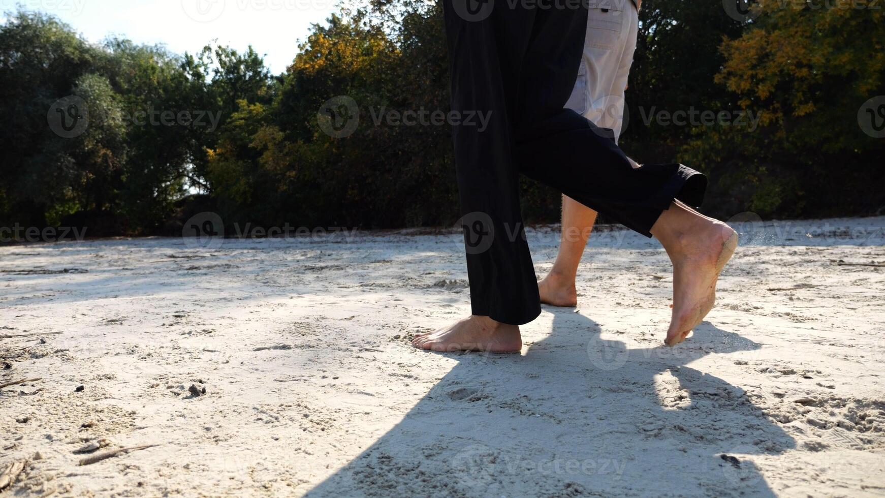 Male and female legs of pair walking on sandy beach.Bare feet of couple stepping along sand shore at sunny day. Lovers spending time together at resort. Concept of summer vacation or holiday photo