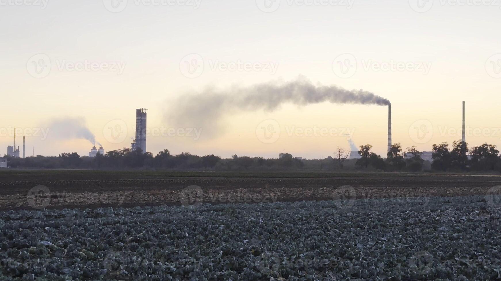 Heavy gray smoke is poured from the chimney pipes of thermal power plant.Carbon dioxide emitting from chimneys from industrial factory into the atmosphere. Concept of environmental pollution problem photo