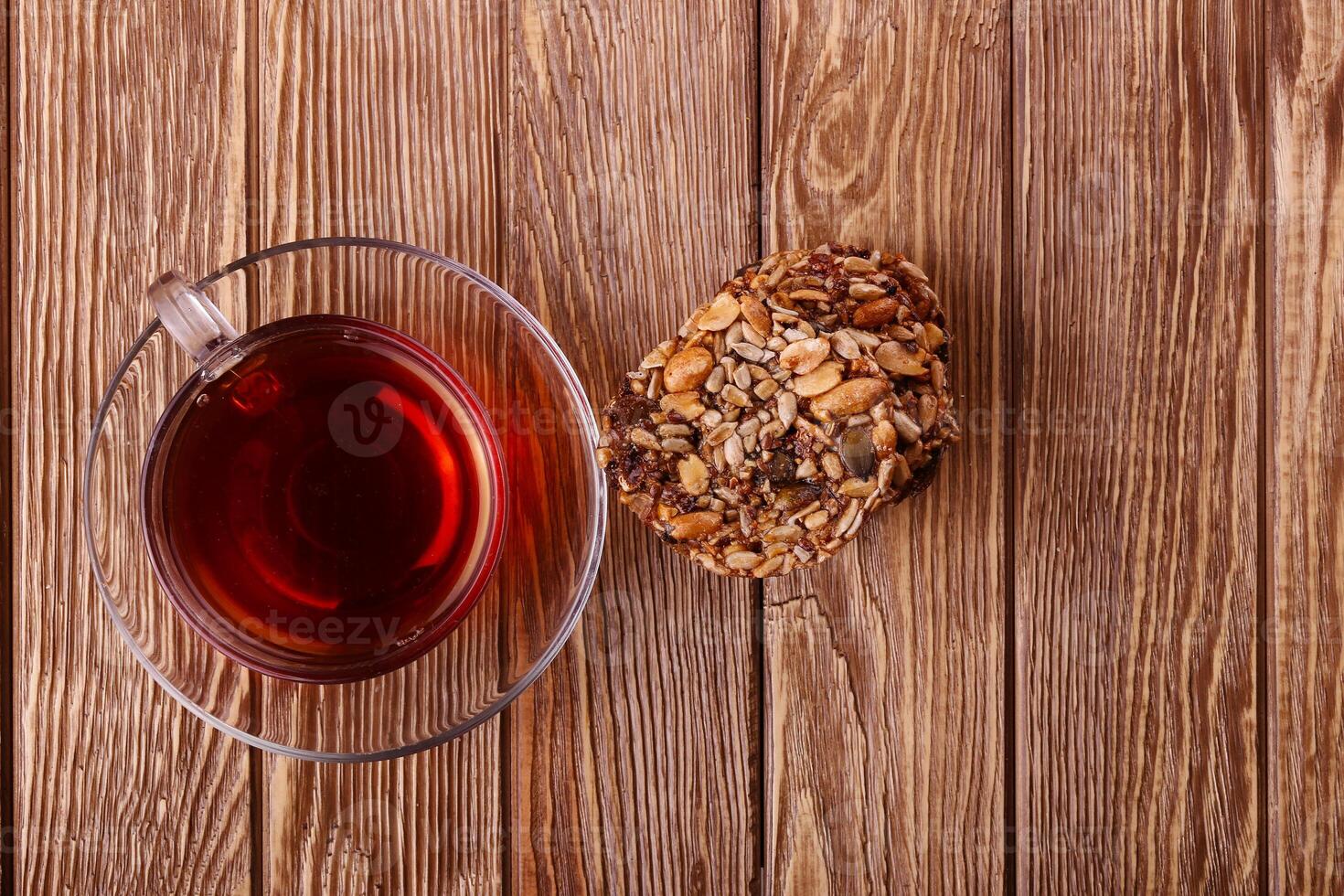 A cup of tea and a biscuit on a wooden table photo