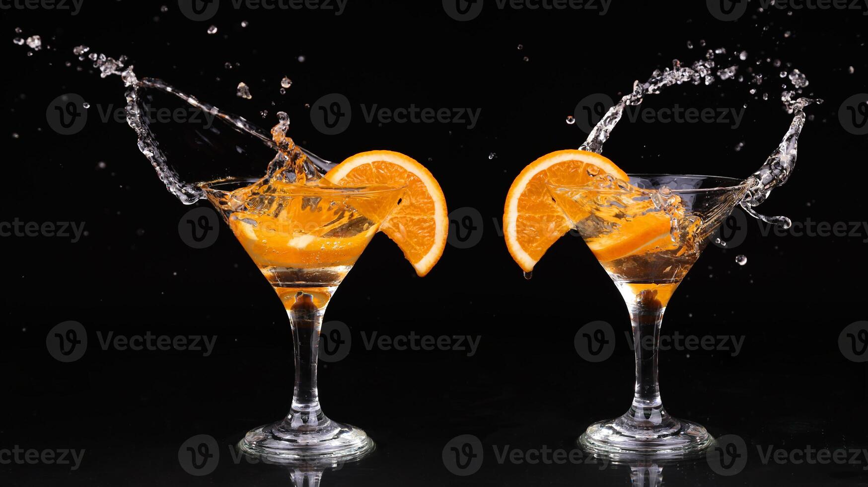 Two glasses with orange slices and water splashing photo
