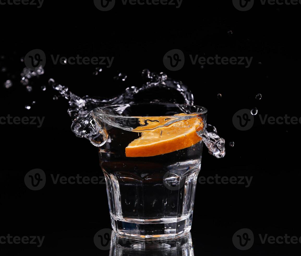 A shot glass with a slice of orange in it photo