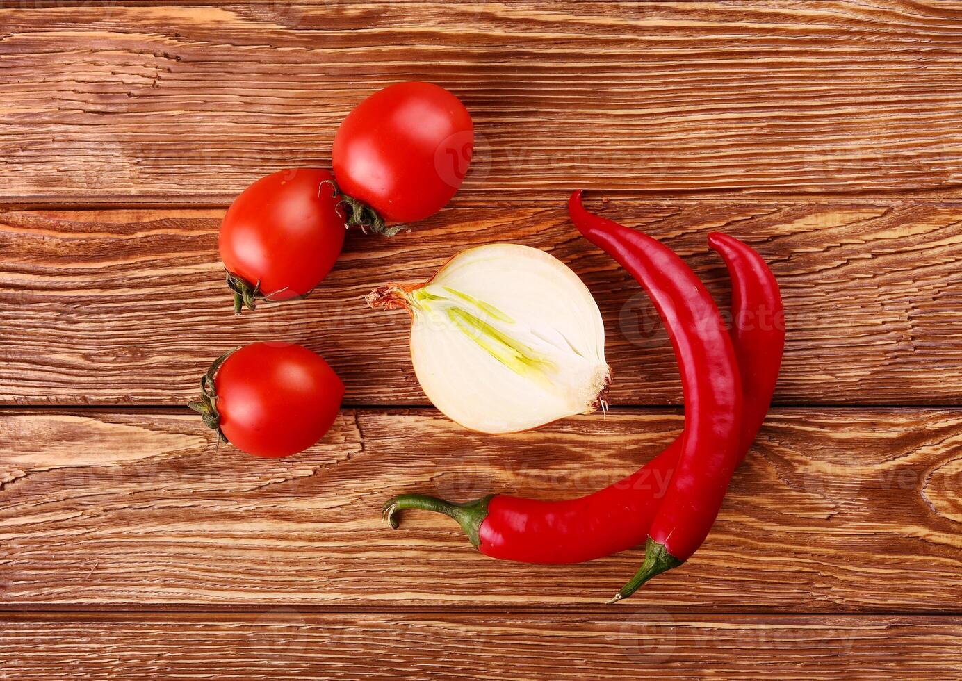Tomatoes, onion and pepper on a wooden table photo