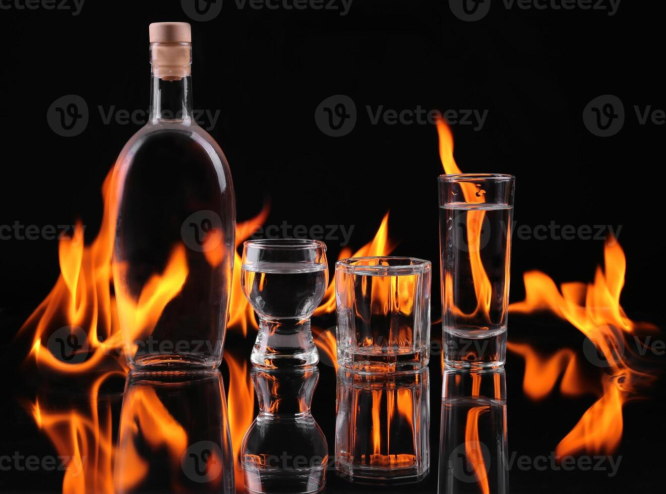 A bottle of vodka and two glasses on a black background photo