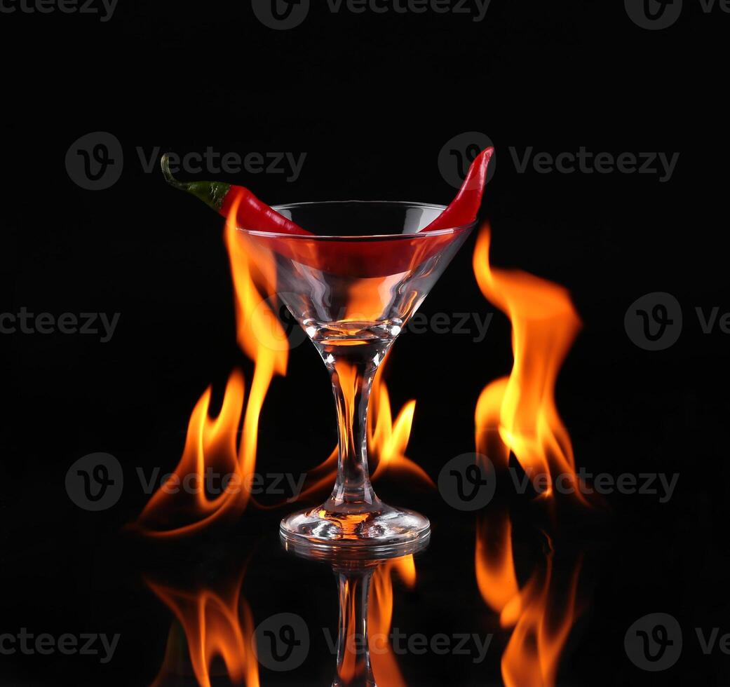 A martini glass with a chili pepper in the flame photo