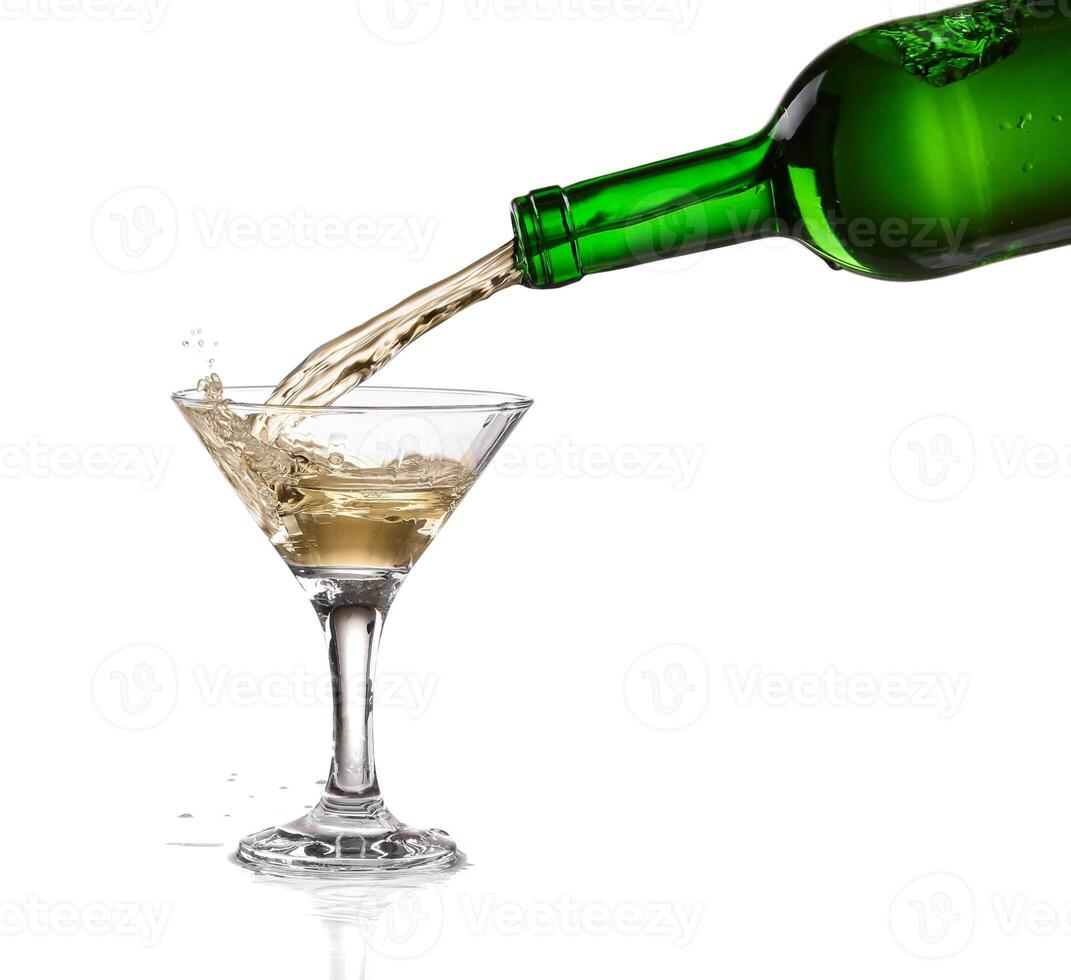 A bottle of wine pouring into a martini glass photo