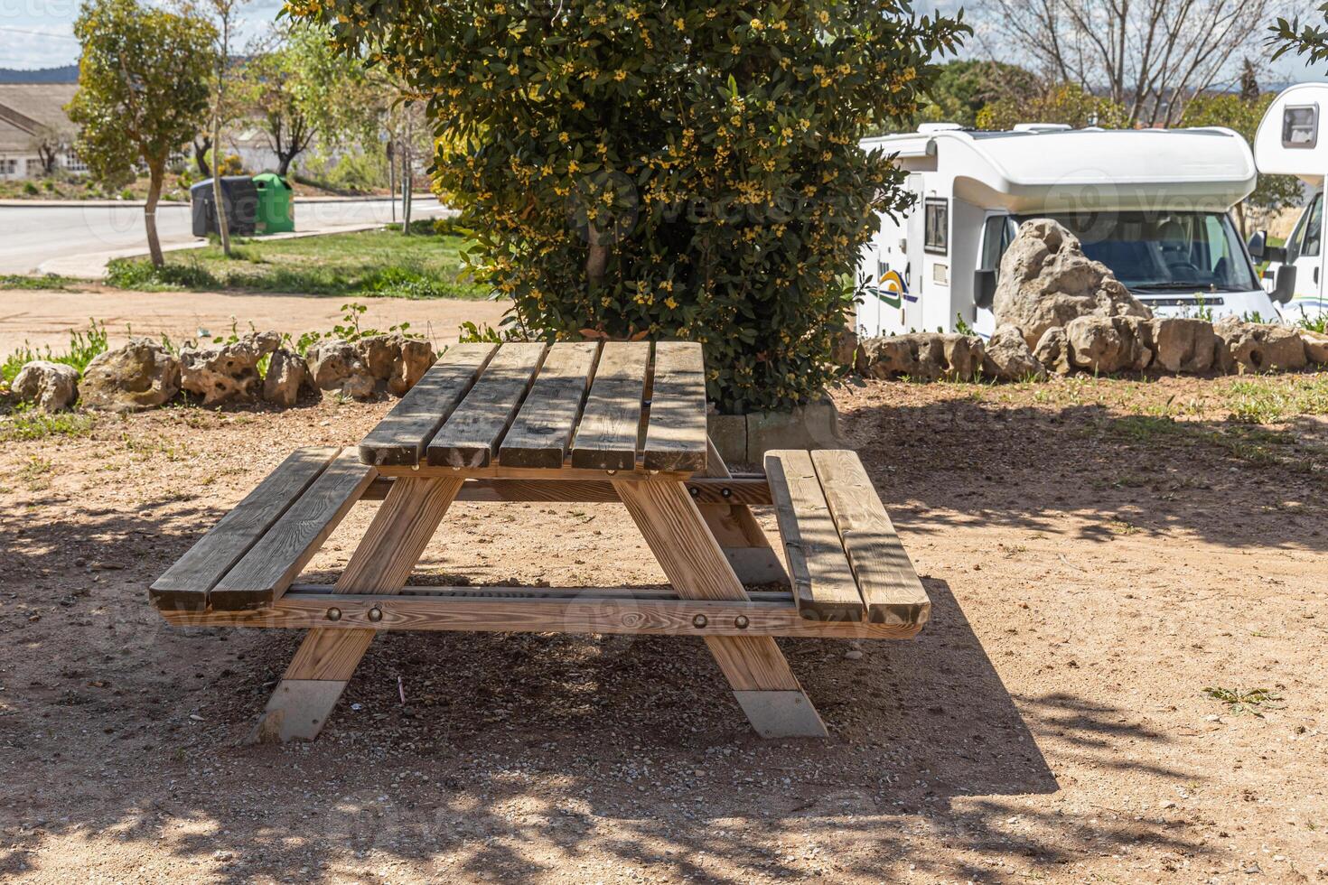 Empty gray wooden table on the green plants background with motorhome photo
