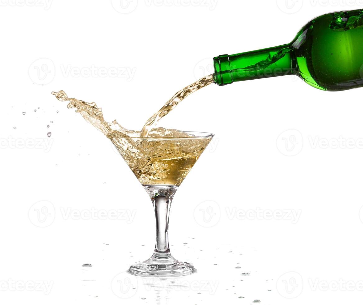 A bottle of wine being poured into a martini glass photo