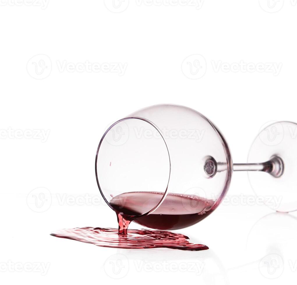 A wine glass with red liquid pouring out of it photo