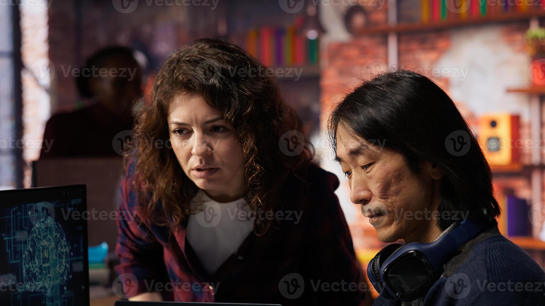 Engineers cooperating in AI focused startup, debugging applications, crosschecking between PC and laptop. Coworkers doing code testing and quality assurance on devices, camera B close up photo