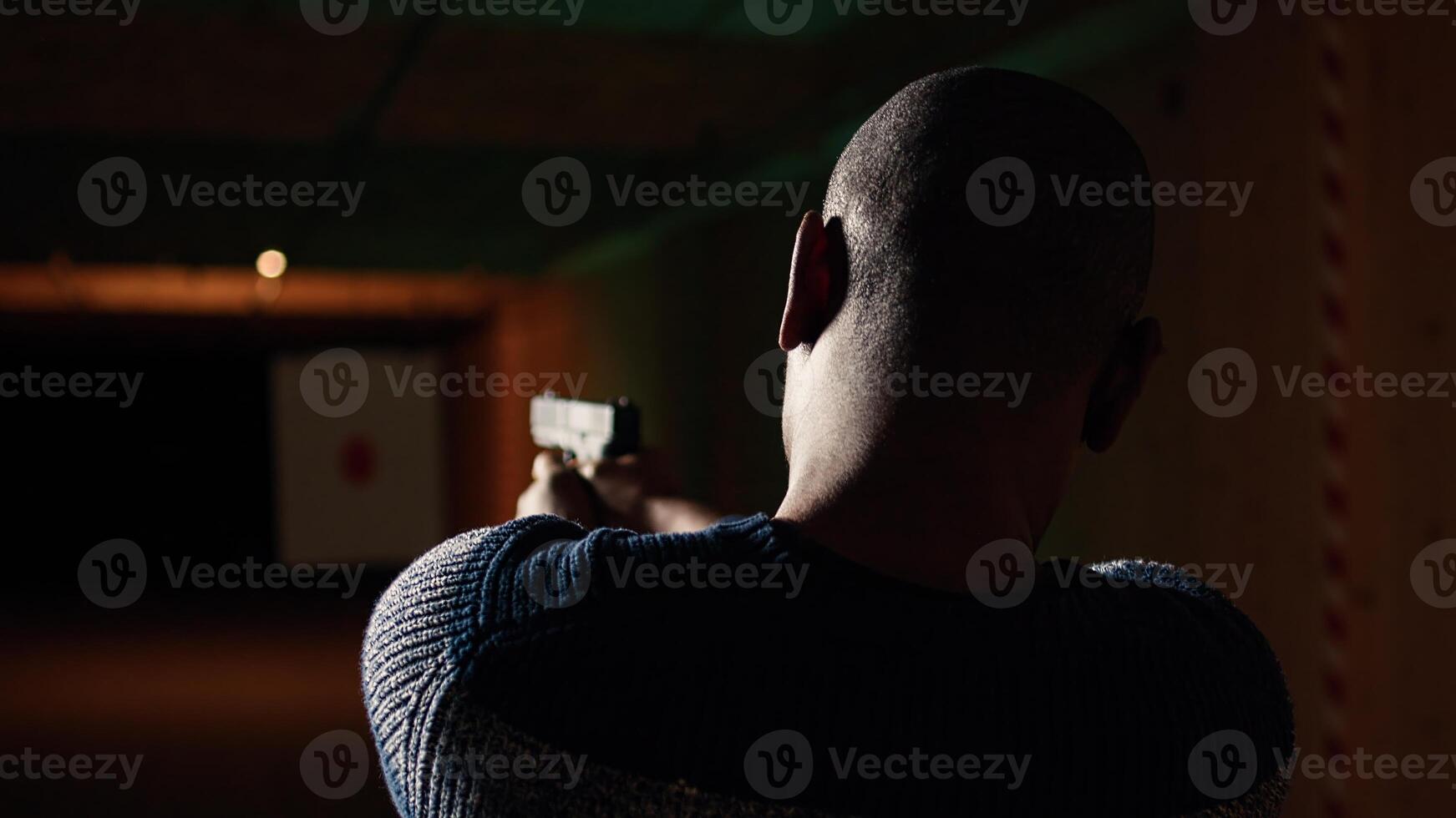 Shooting gallery customer using pistol to hit paper targets with ammo. Close up shot of man at professional firing range, shooting bullseyes, enjoying using weapons, camera A photo