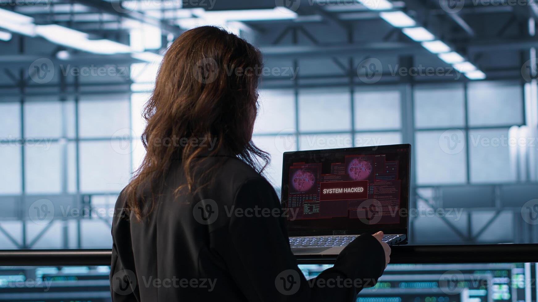 Cybersecurity expert in data center frantically trying to counter hacker attack. Server room worker under pressure to secure sensitive information after threat alert received on laptop, camera A photo