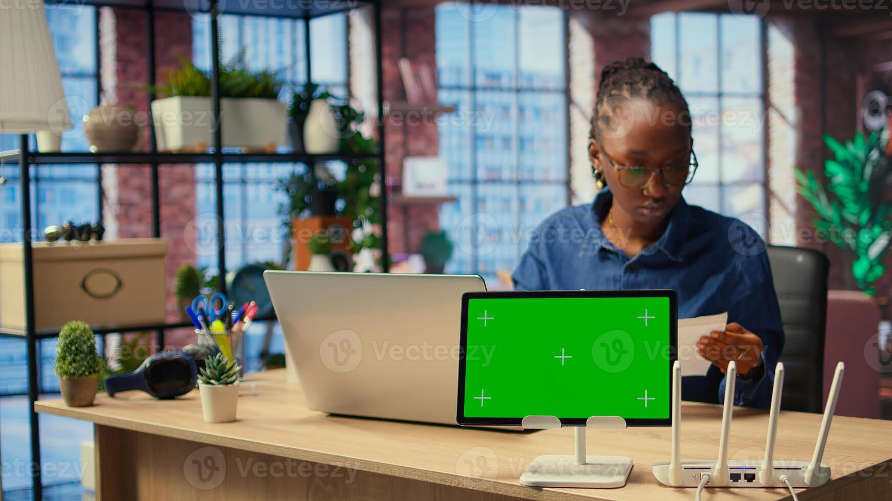 Female freelancer browsing troubleshooting guide next to copy space, working on debugging router issues to restore home network. Young woman struggles to solve tasks. Camera A. photo