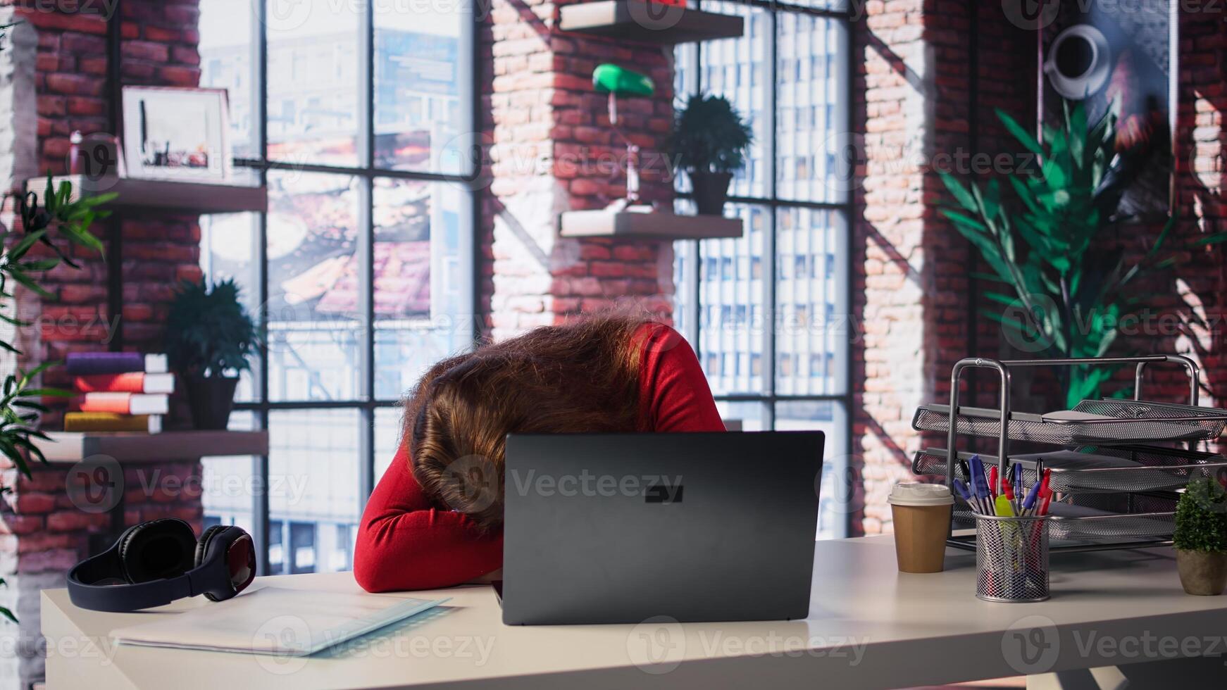 Exhausted woman trying to solve daily tasks on laptop, struggling to pay attention on remote freelance work. Person yawning and being overworked surfing the web at home office. Camera B. photo