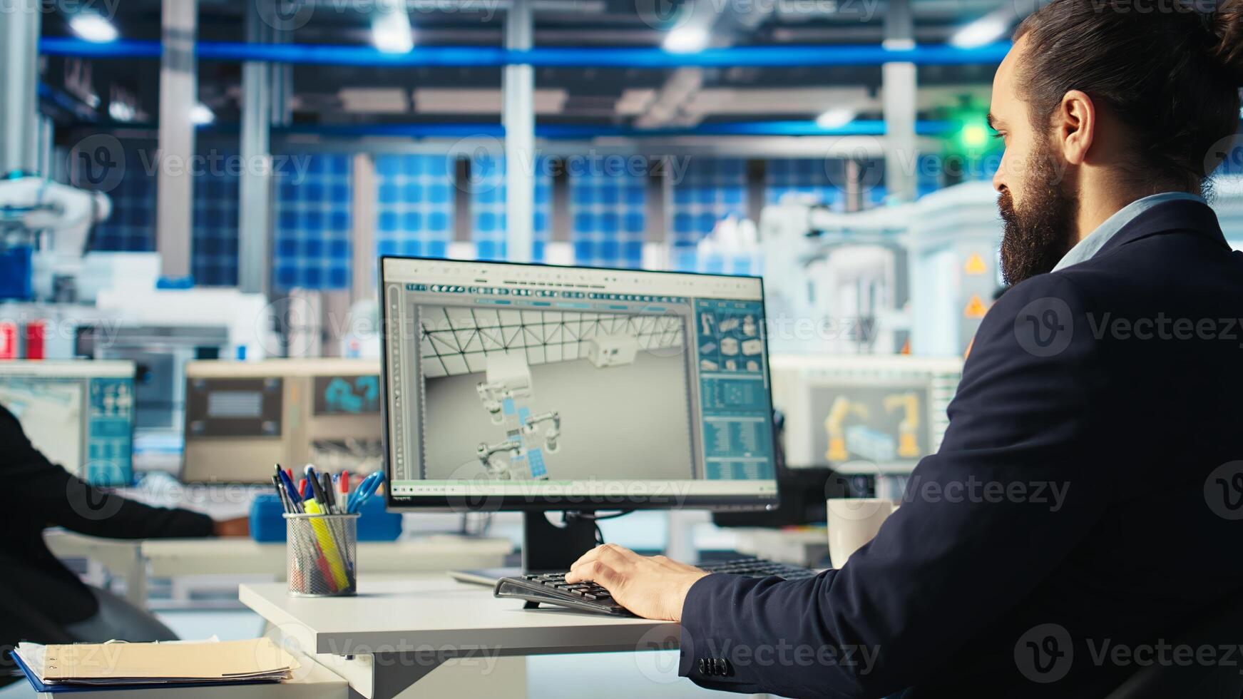 Man in photovoltaics factory monitoring system performance on PC. Solar panels manufacturing plant employee at computer desk tracking energy production and efficiency, camera A photo