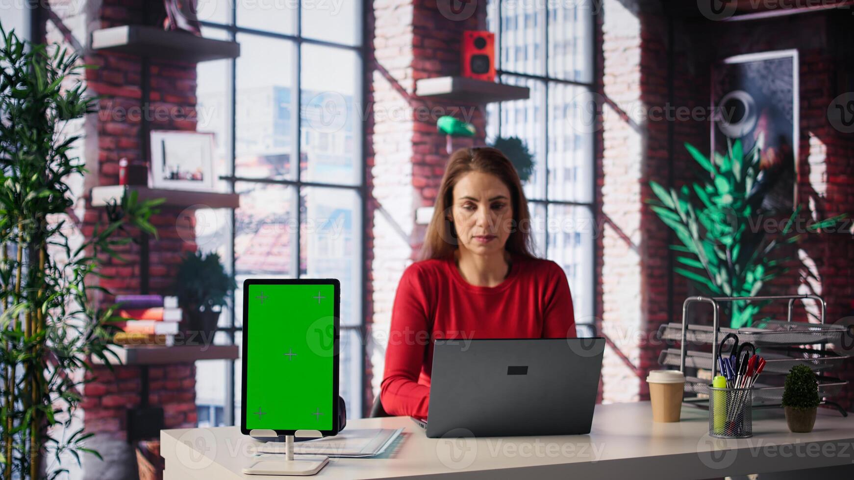 woman solving tasks on a freelance platform next to mockup screen, answering emails and multitasking. Person staying connected and enjoying flexibility of working from home. Camera B. photo
