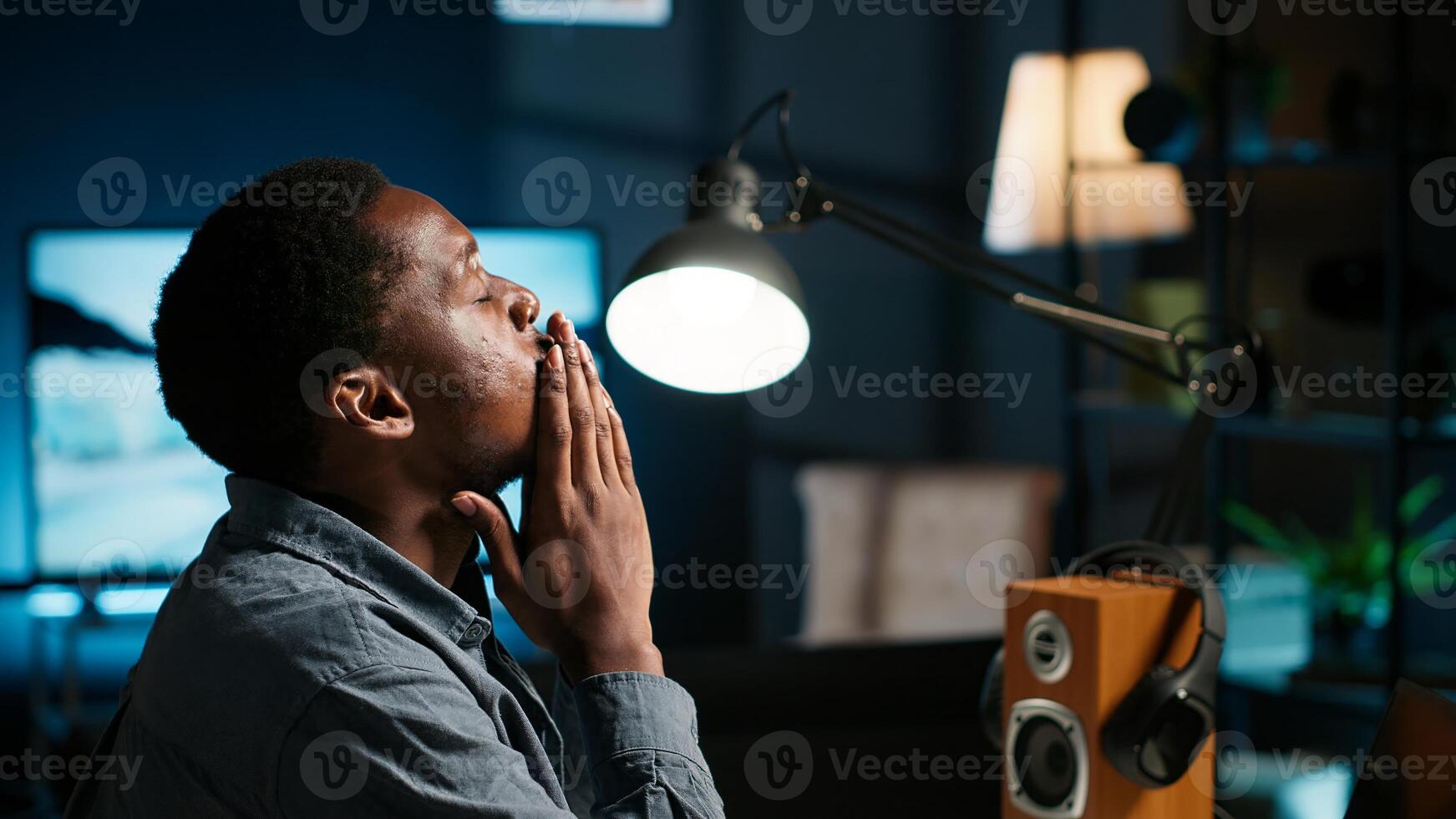 Black developer feeling exhausted and trying to meet task deadline. African american guy being under pressure, working hard to finish report in time and dealing with headache. Camera B. photo