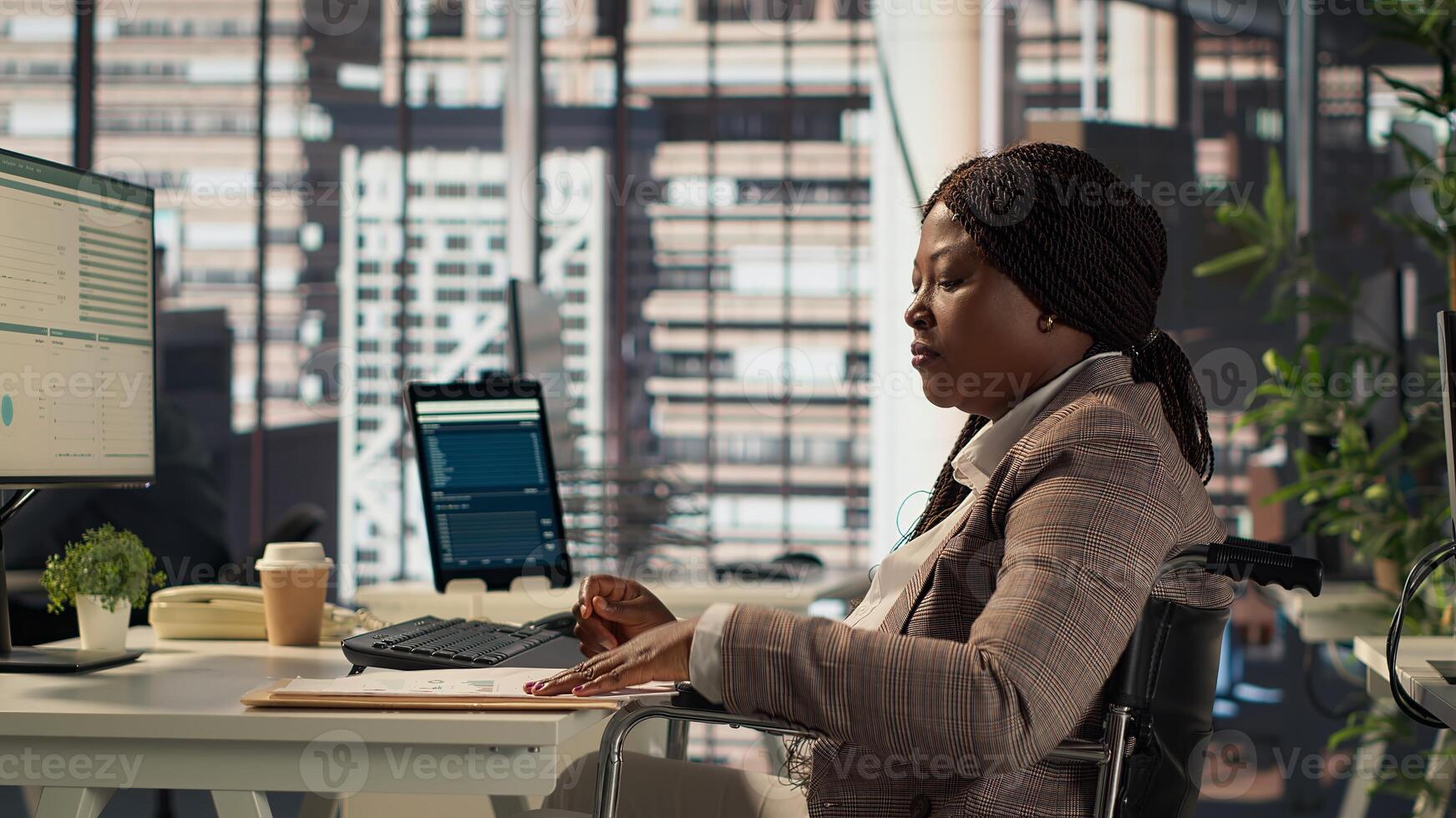 Female boss with disability examining archived files and data reports, creating financial plan before allocating resources. Businesswoman in wheelchair reviews infographics. Camera A. photo