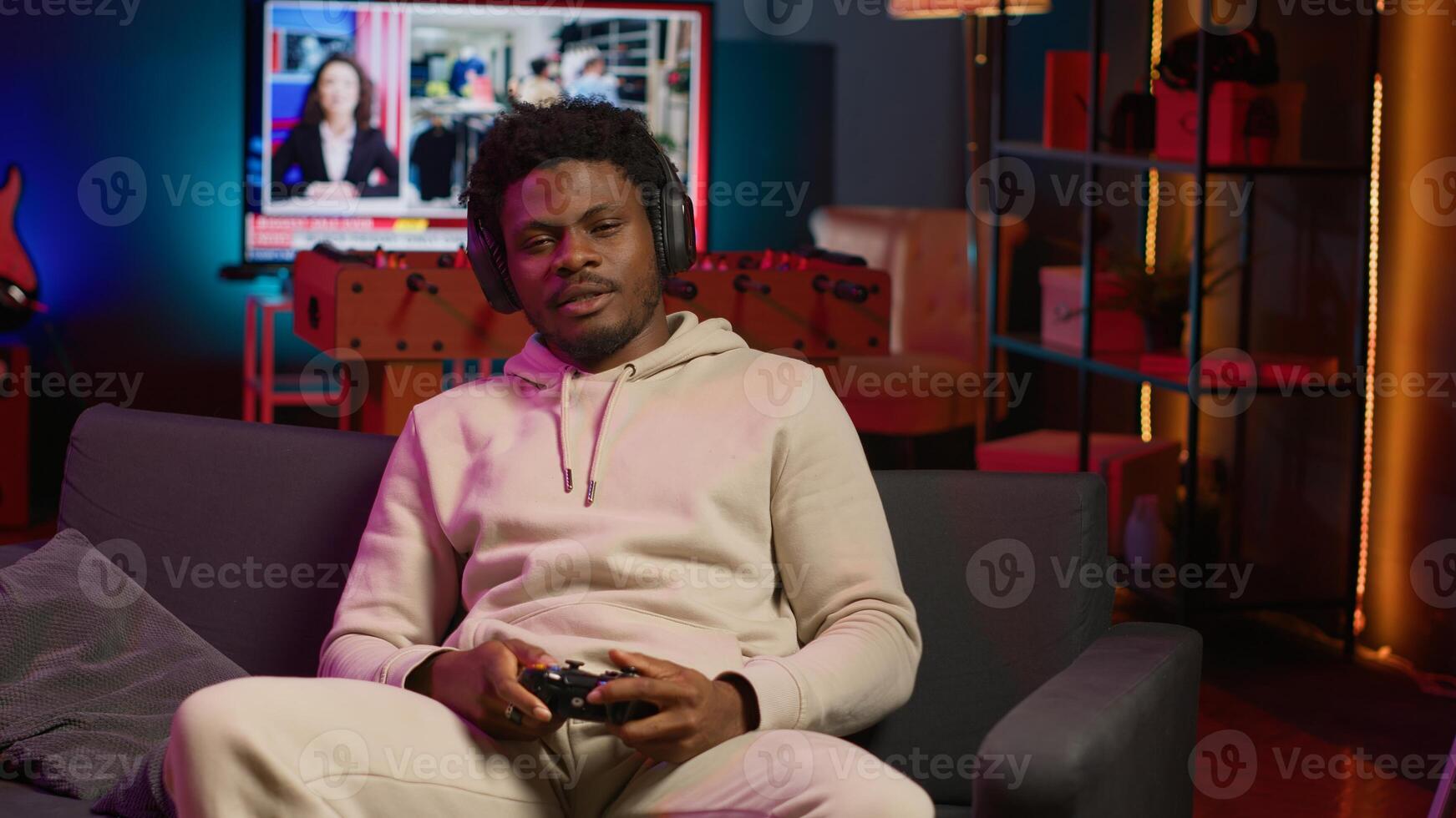 African american man plays intense online games at home, spamming attack buttons on controller. Gamer participating in virtual competition, playing on gaming console. Camera A. photo