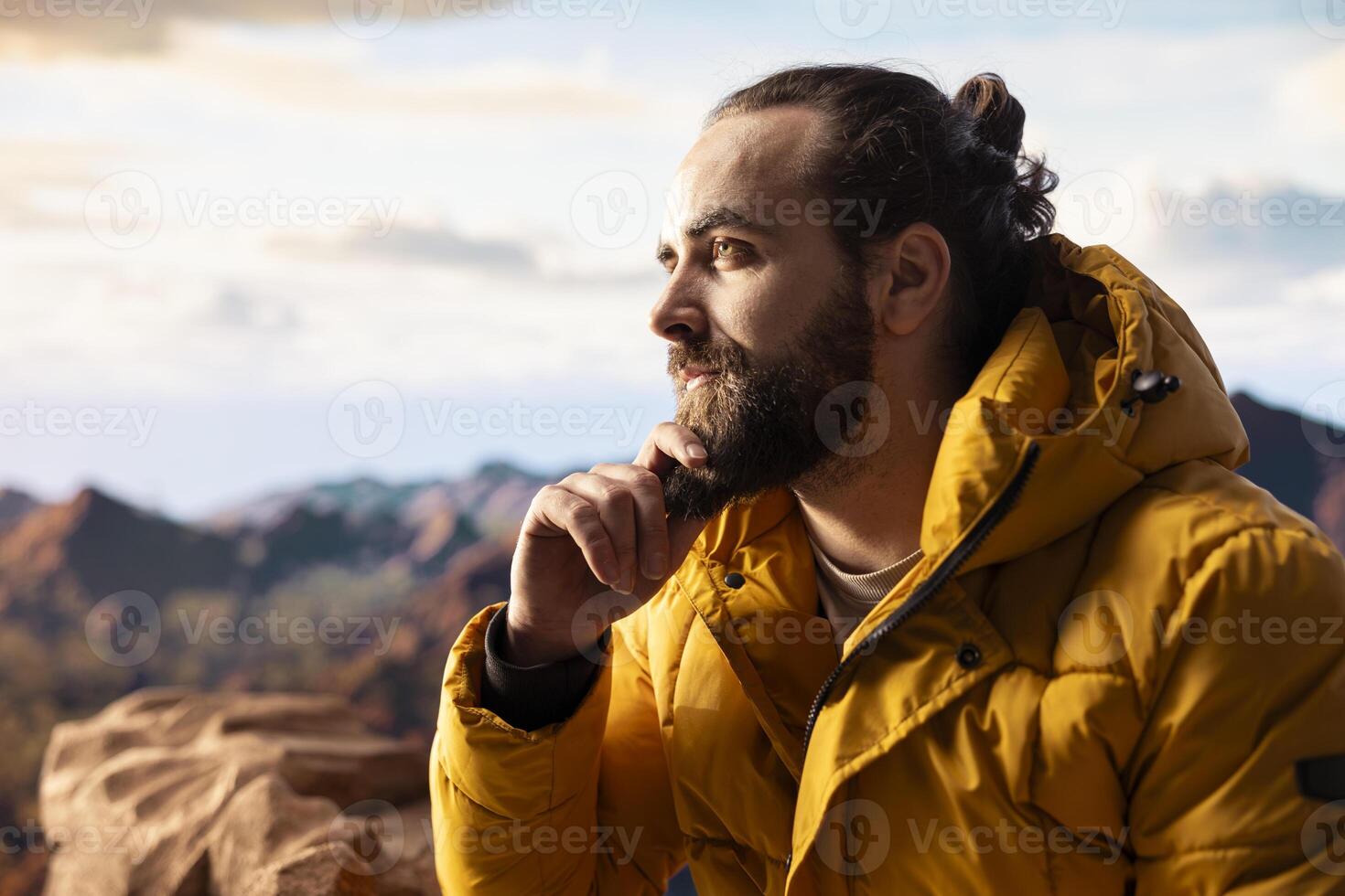 Determined traveler enjoys solitude of mountain summit, where panoramic view represents adventure and personal growth. Hiker with outdoor gear feeling cold on windy mountain top. photo