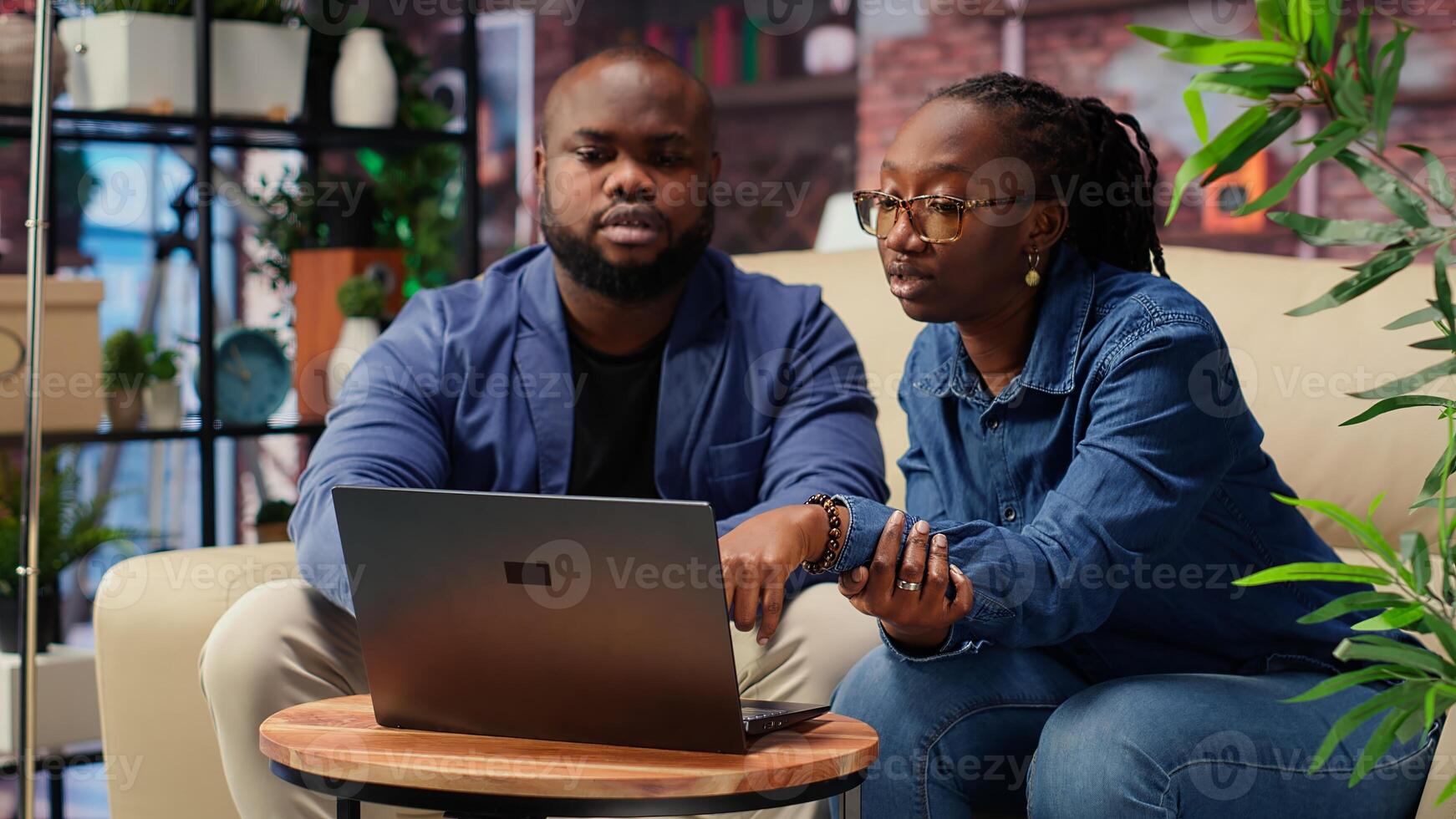 African american couple work on management project for freelancing, using laptop to research business trends and manage online brand. Successful remote career development. Camera B. photo