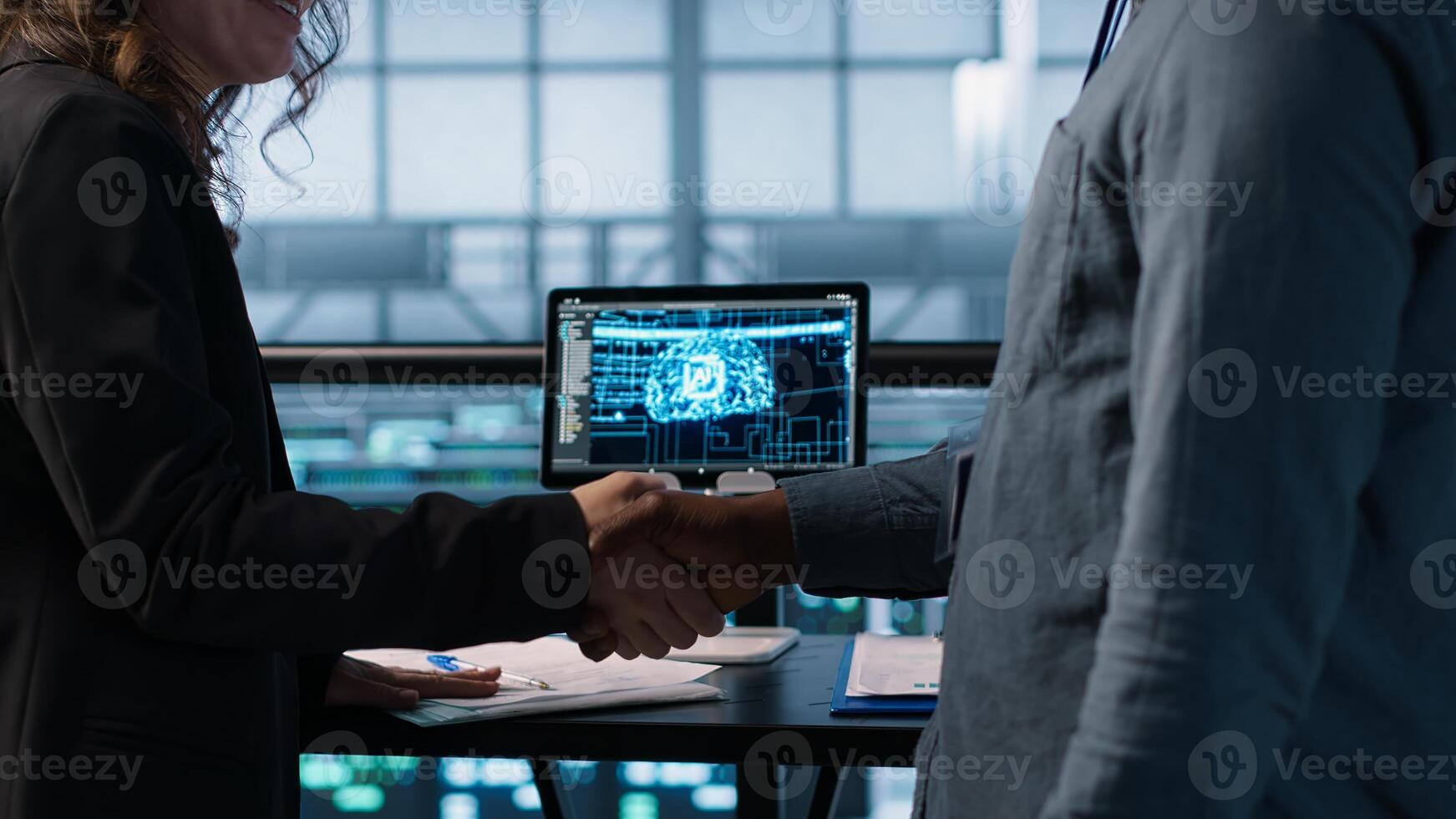 Manager meeting with client in data center using artificial intelligence tech, reaching deal. People handshaking in AI based server farm after checking files and finishing transaction, camera A photo