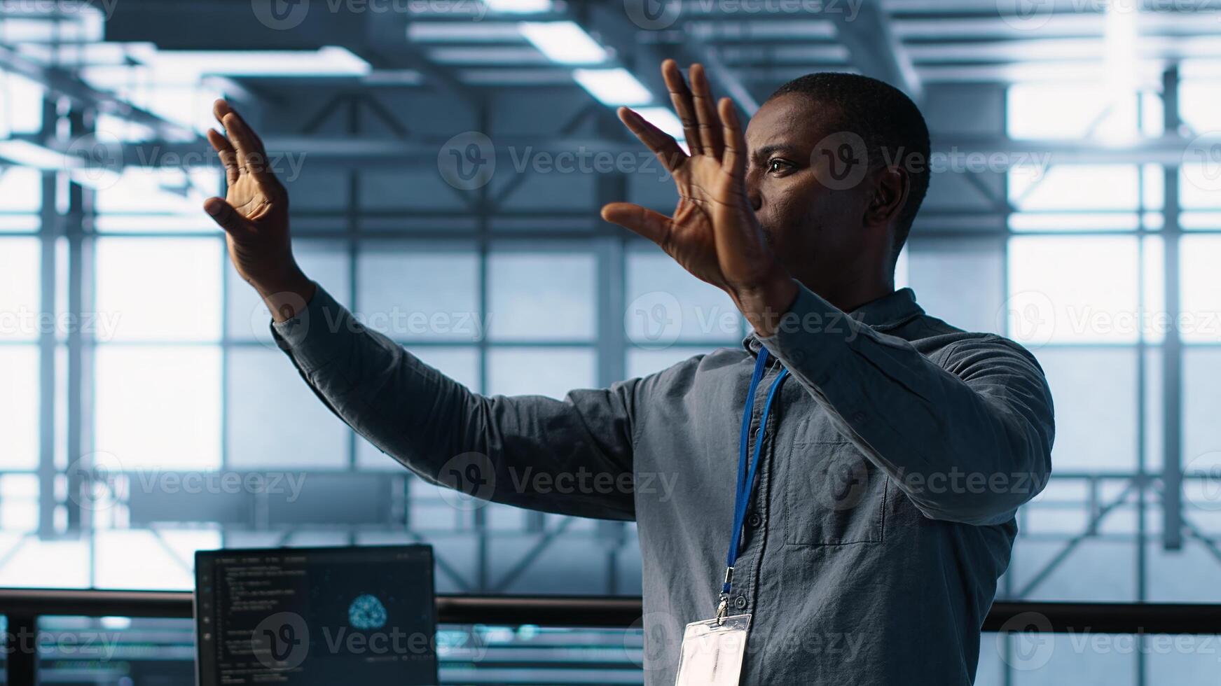 Computer scientist looking at holograms in data center, using artificial intelligence. African american admin interacting with augmented reality visualization in server room, camera A photo