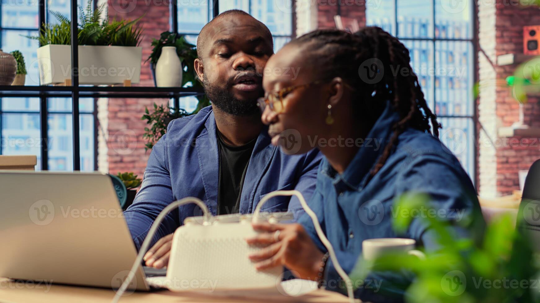 Angry woman pulling out LAN cable from router while her partner reads technical manual for troubleshooting. Couple getting mad and arguing over signal loss. Camera B. photo