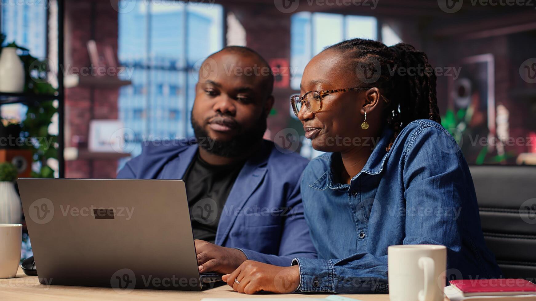 Black freelancers at home desk using laptop and checking emails, reading messages in inbox and solving daily tasks. Couple managing electronic correspondence. Camera B. photo