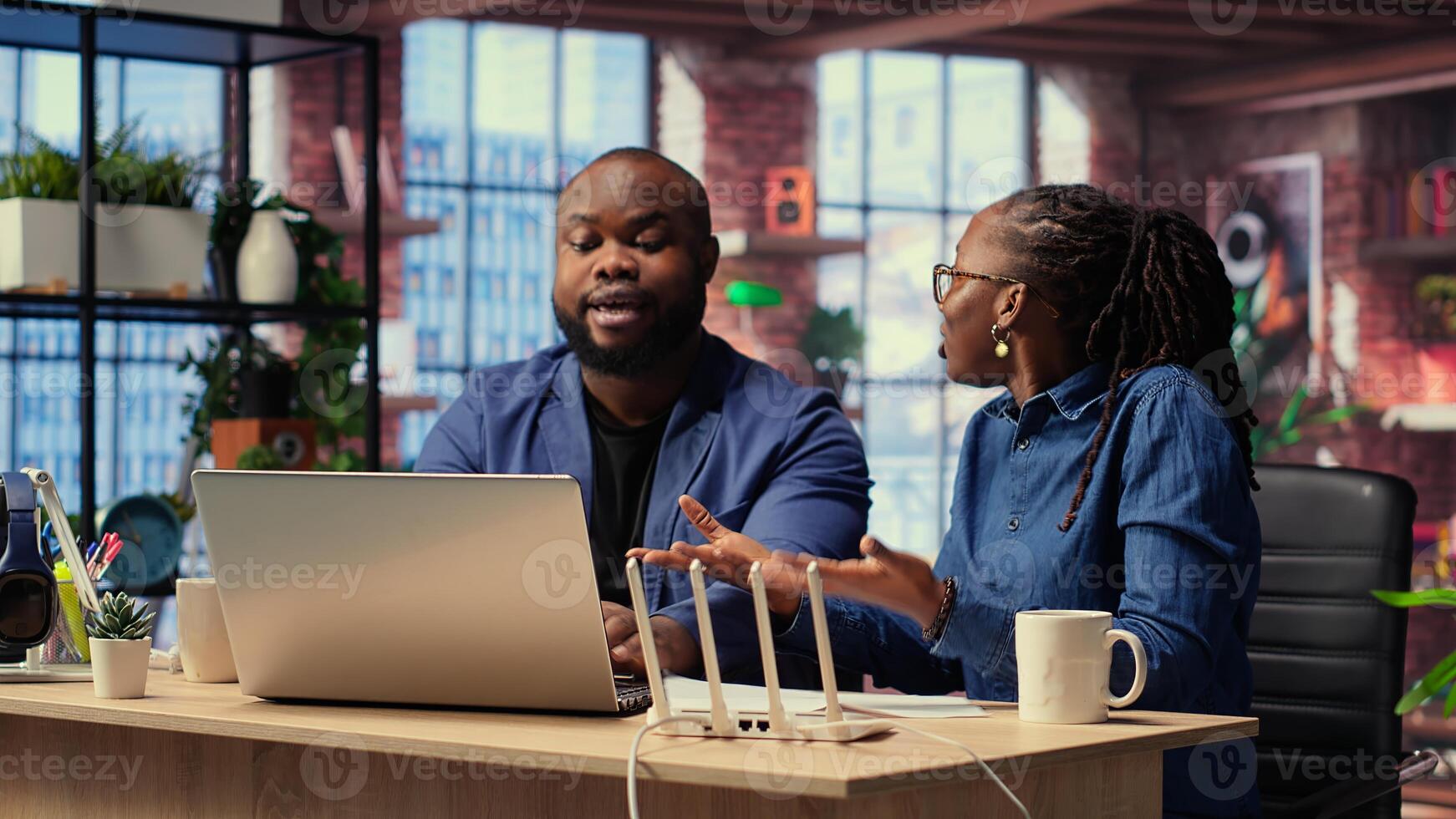 African American people try to reset WiFi modem due to signal loss, woman arguing and being irritated. Frustrated couple fighting over troubleshooting methods. Camera B. photo