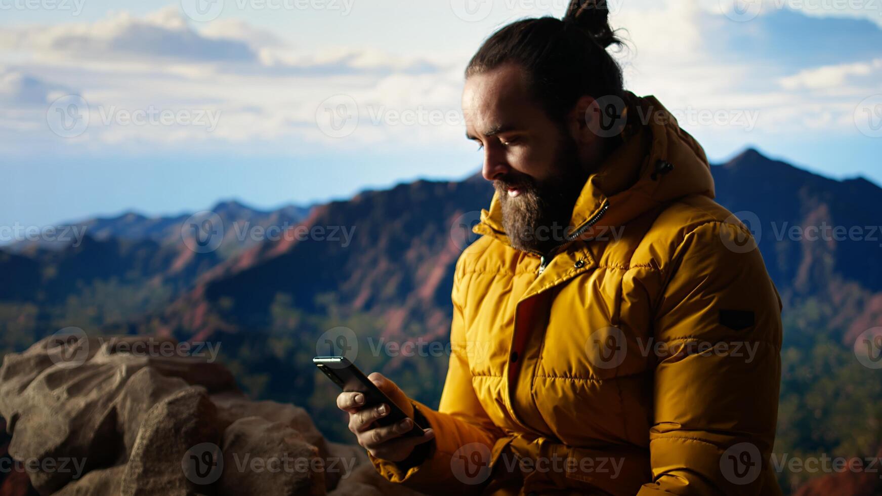 Nature lover relaxing on mountain getting online with phone at scenic viewpoint, looking out over landscape. Hiker staying on social media and connected, panoramic scenery. Camera A. photo