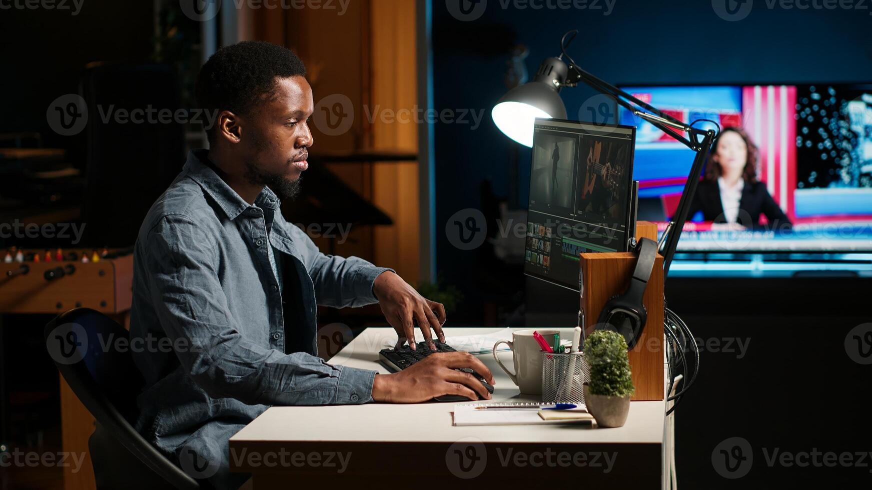 Focused editor working on montage in creative software at home office setup, digital media content. Filmmaker using dual monitors to edit footage in post production. Camera B. photo