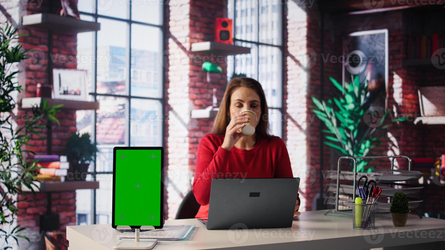 Person using laptop for creative projects next to isolated copy space, creating designs and staying connected to freelance platform. Woman focusing on research and multitasking. Camera B. photo