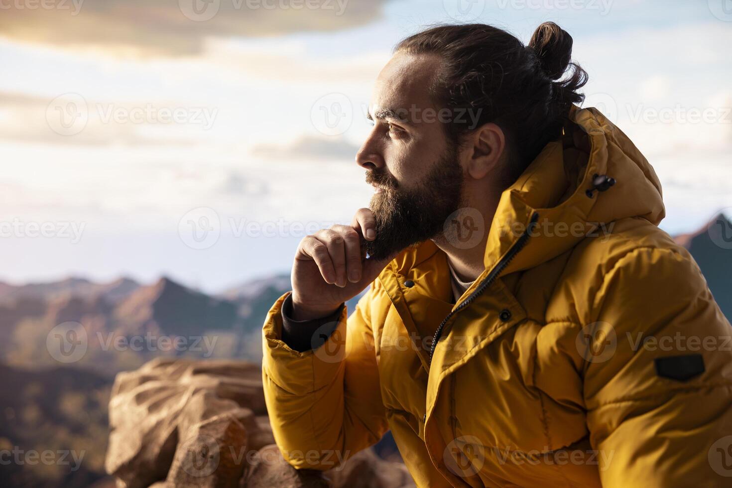 Hiker gazing at panoramic view of mountain peaks and clouds, feeling thrill of adventure and rewards of perseverance. The journey represents strength and personal growth. photo