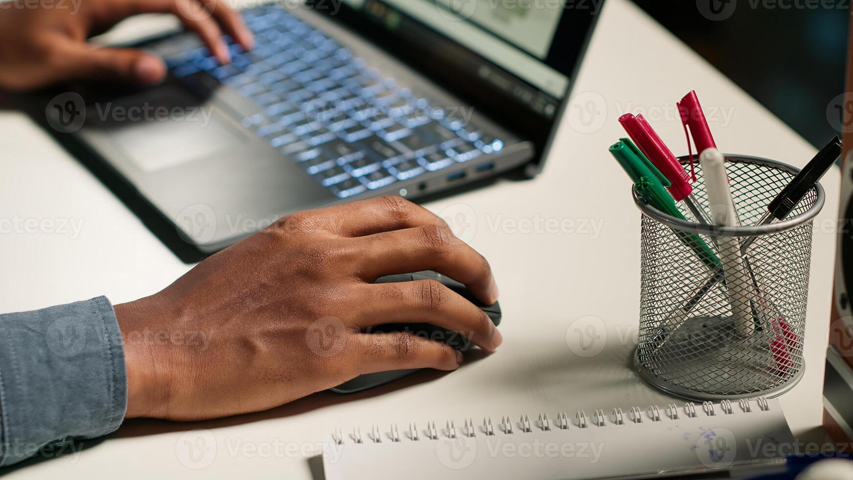Independent worker balancing freelance tasks and researching articles, starting day answering emails. Young adult typing project notes, gathering information for work improvement. Camera B. photo
