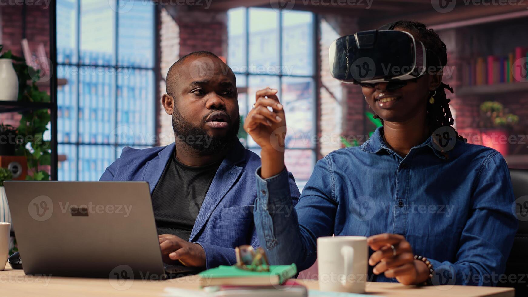 Black people integrate VR and AI into daily job routine where woman engages in immersive 3D experience. Young woman reviews animation on headset within metaverse. Camera B. photo