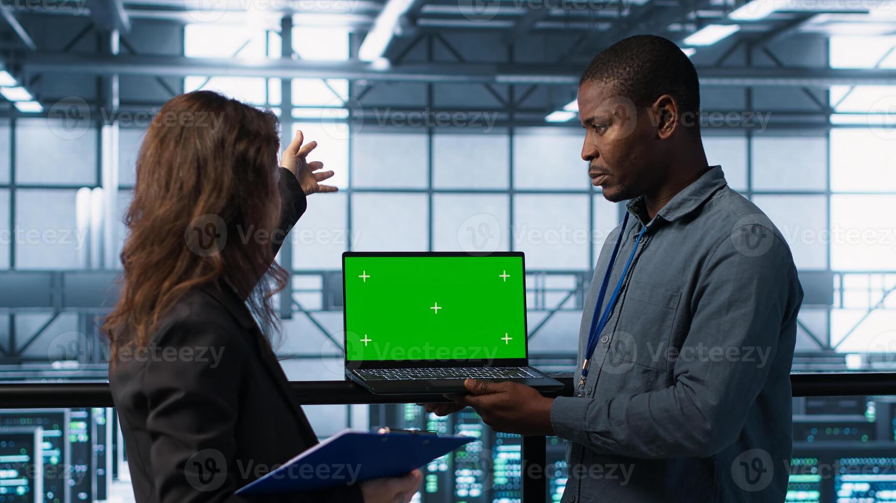 Engineering team using green screen laptop, implementing predictive analytics scripts, reviewing equipment health, adjusting system parameters and coordinating maintenance tasks, camera A photo