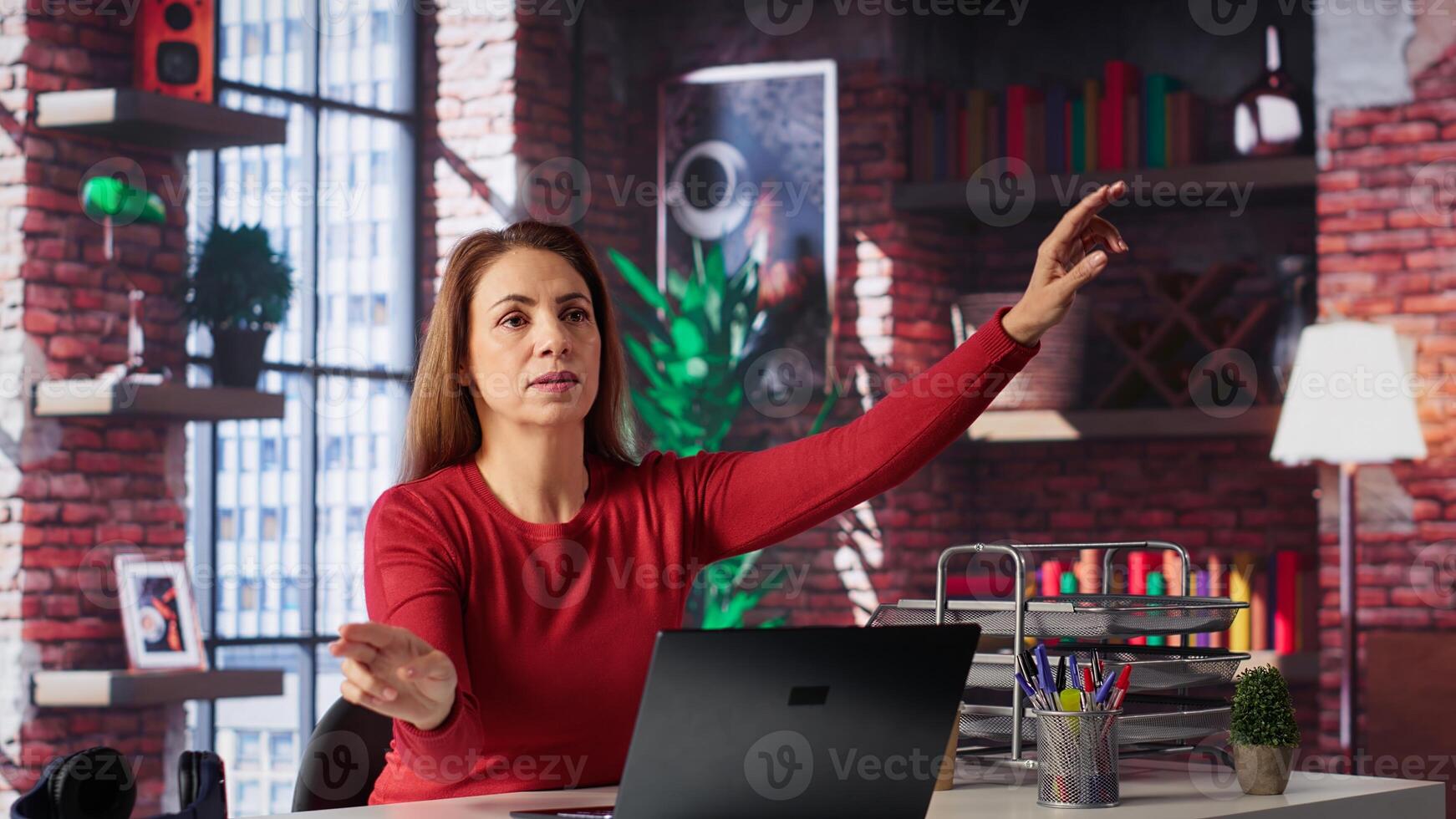Freelancer reviewing holographic images with digital AI innovation, looking at hologram projection at home. Woman employs artificial intelligence visualization. Camera A. photo