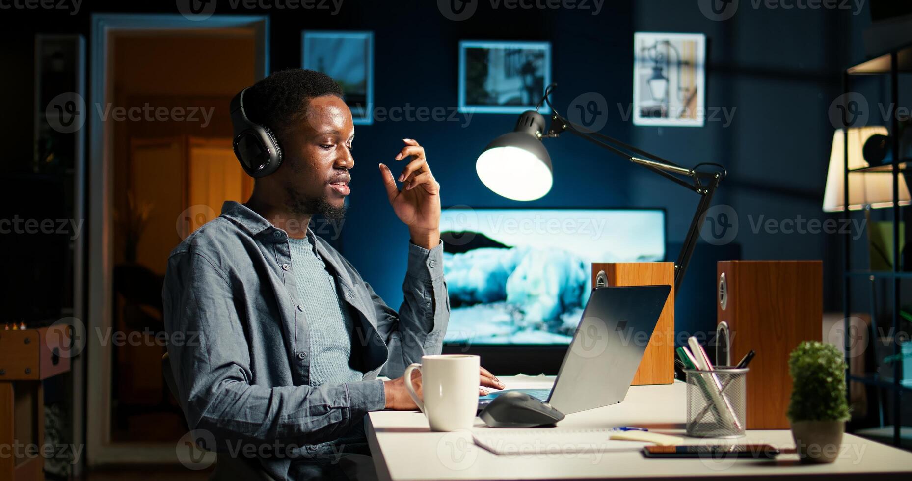 African American guy waving at call with workmates, working remotely from apartment and participating in executive meetings. Virtual communication. Camera A. photo