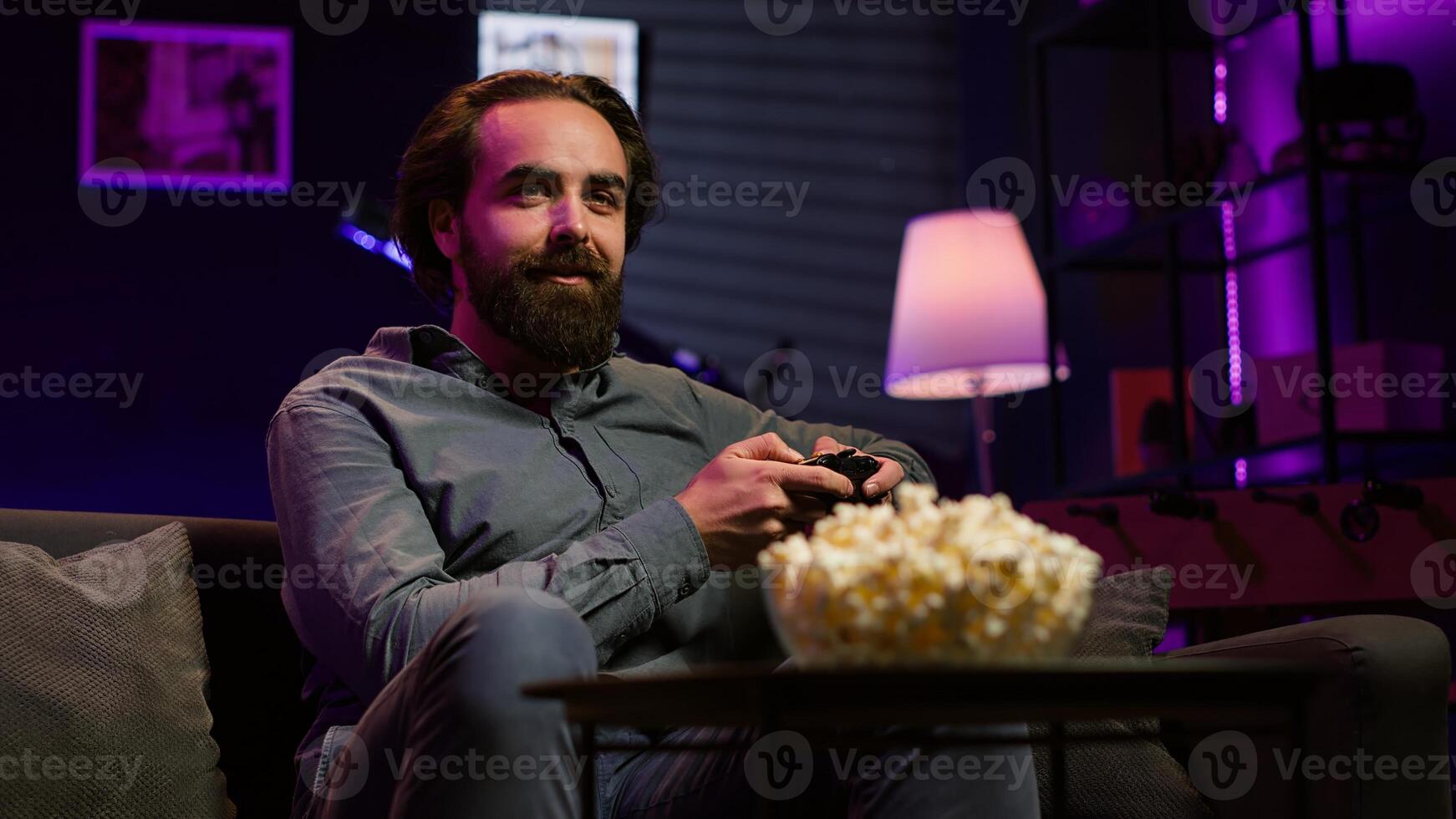 Cheerful gamer engaging in online competitive multiplayer tournament using gaming console. Upbeat player playing fun videogames, enjoying leisure time, camera A photo