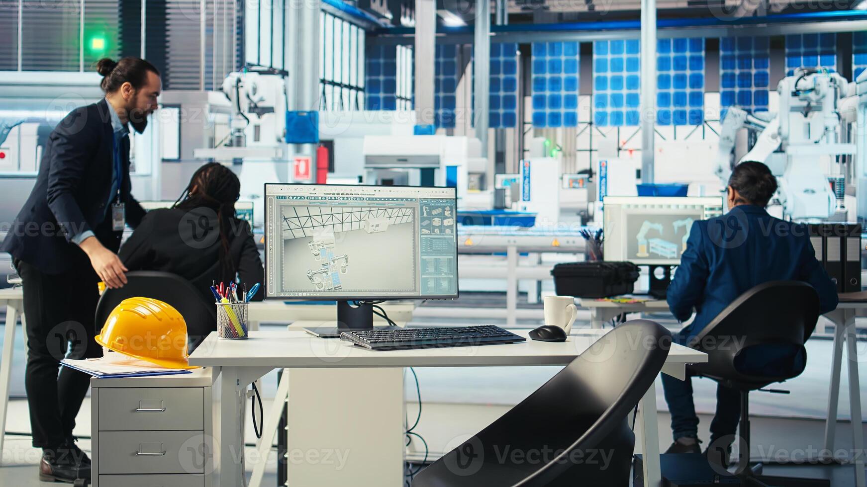 Factory manager walking to employees desks to give tasks after visualizing solar cells designs with 3D software tools, shaping facility floor according to computer simulations photo