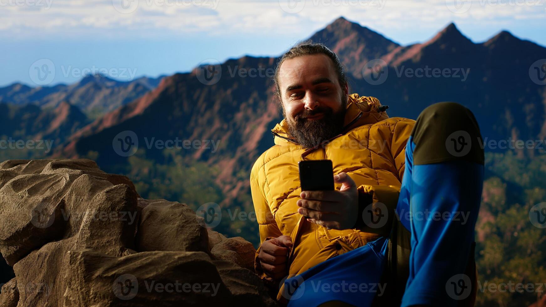 Traveler in warm clothing scrolling social media on top of mountain peak, person always connected with strong signal and obsessed with technology. Climbing hills. Camera B. photo