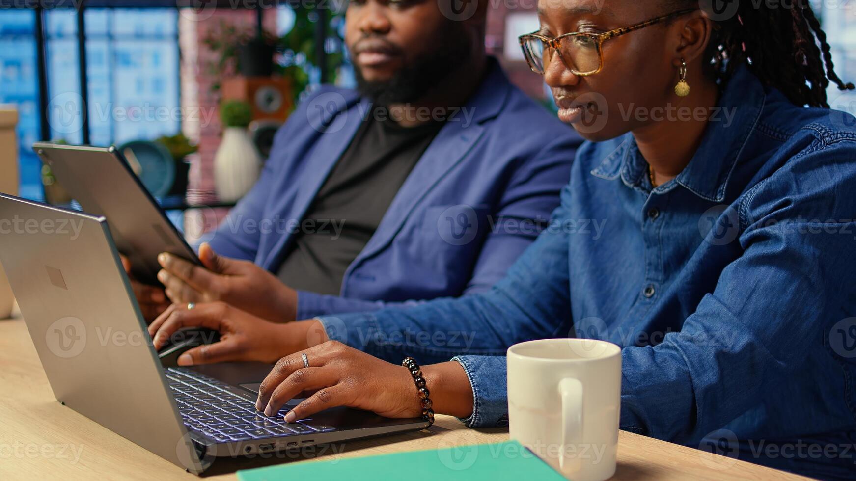 Couple at desk reading research papers and multitasking with laptop at home office, diving into professional or personal topics of improvement. Self employed people review analysis. Camera A. photo