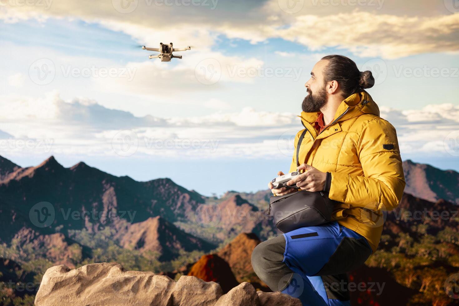 Young nature lover photographer recording mountain valley with drone, sharing hiking journey through vlog with high quality content with remote control. Hiker filming the scenery. photo