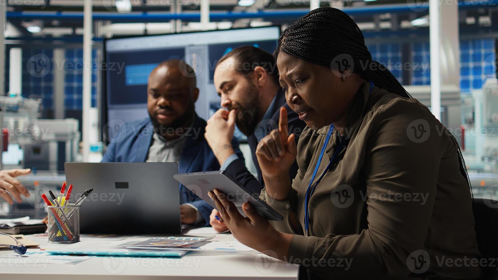 Factory manager works on integrating automation technology in industrial plant, looking at device. Woman analyzing business model on tablet, expanding production, camera A photo