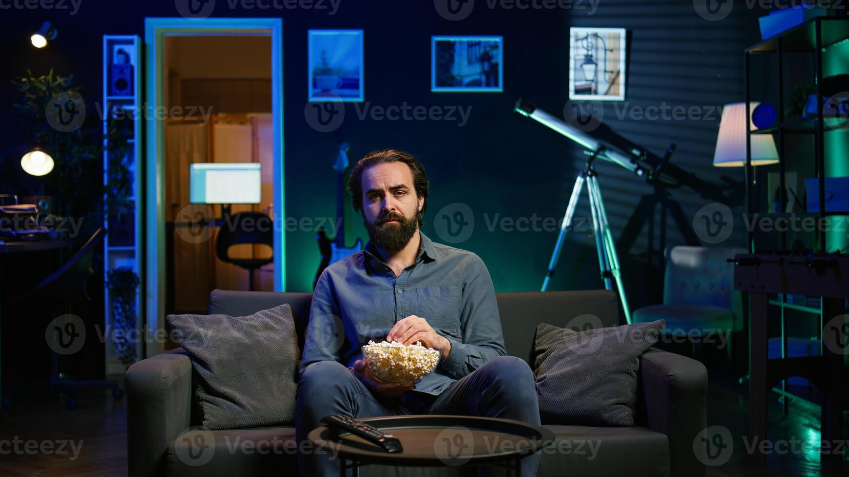 Sad man on couch feeling heartbroken while watching tragic movie on streaming service. Depressed person seeing TV show favorite character dying, showing emotional discomfort, camera B photo