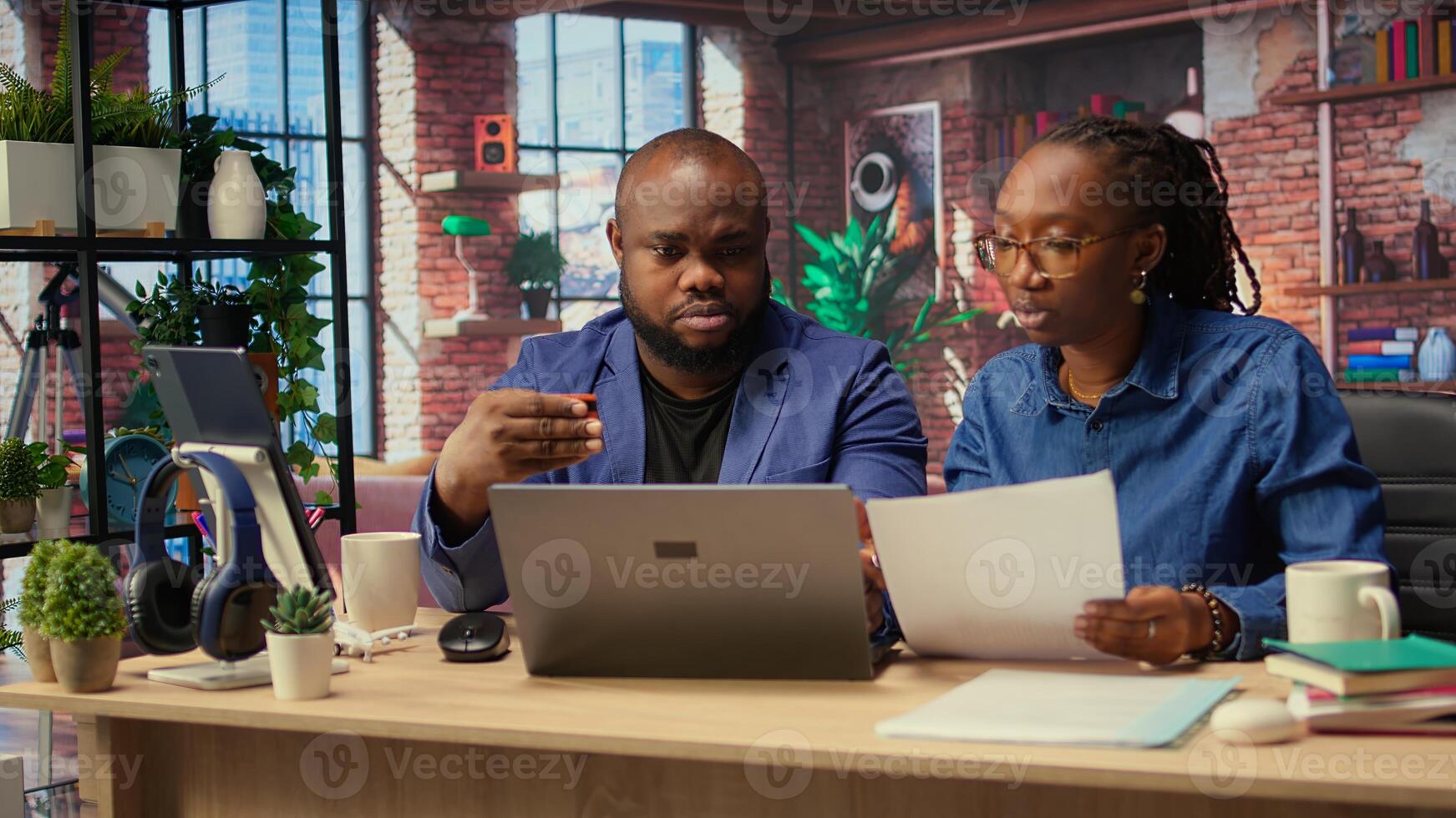 People at home entering card digits to renew account subscription, managing streaming services on laptop. Couple transferring money, updating credentials. Camera A. photo