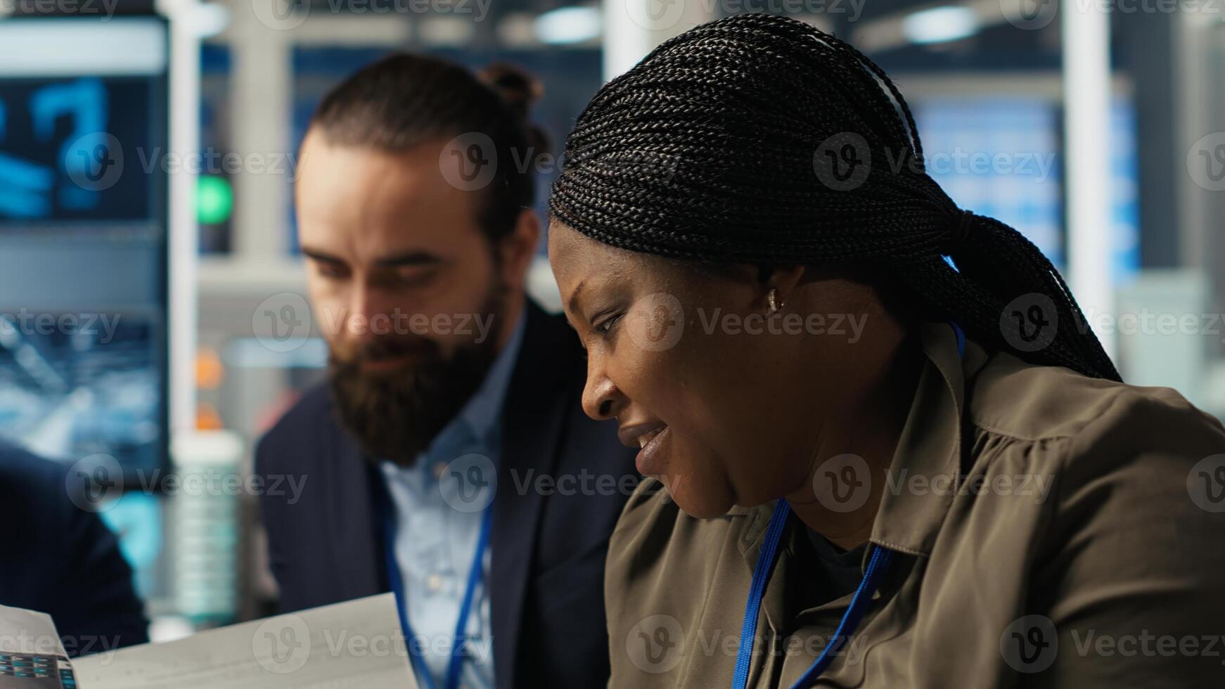 Factory manager works on integrating automation technology in industrial plant, looking at device. African american woman analyzing business data on tablet, expanding production, camera B photo