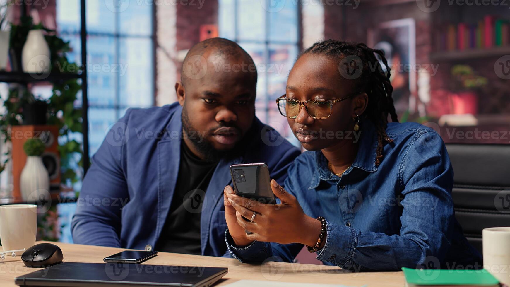 African american man and woman solving freelance tasks at home, working together on phones to finish important project for employer. Networking with partners. Camera B. photo